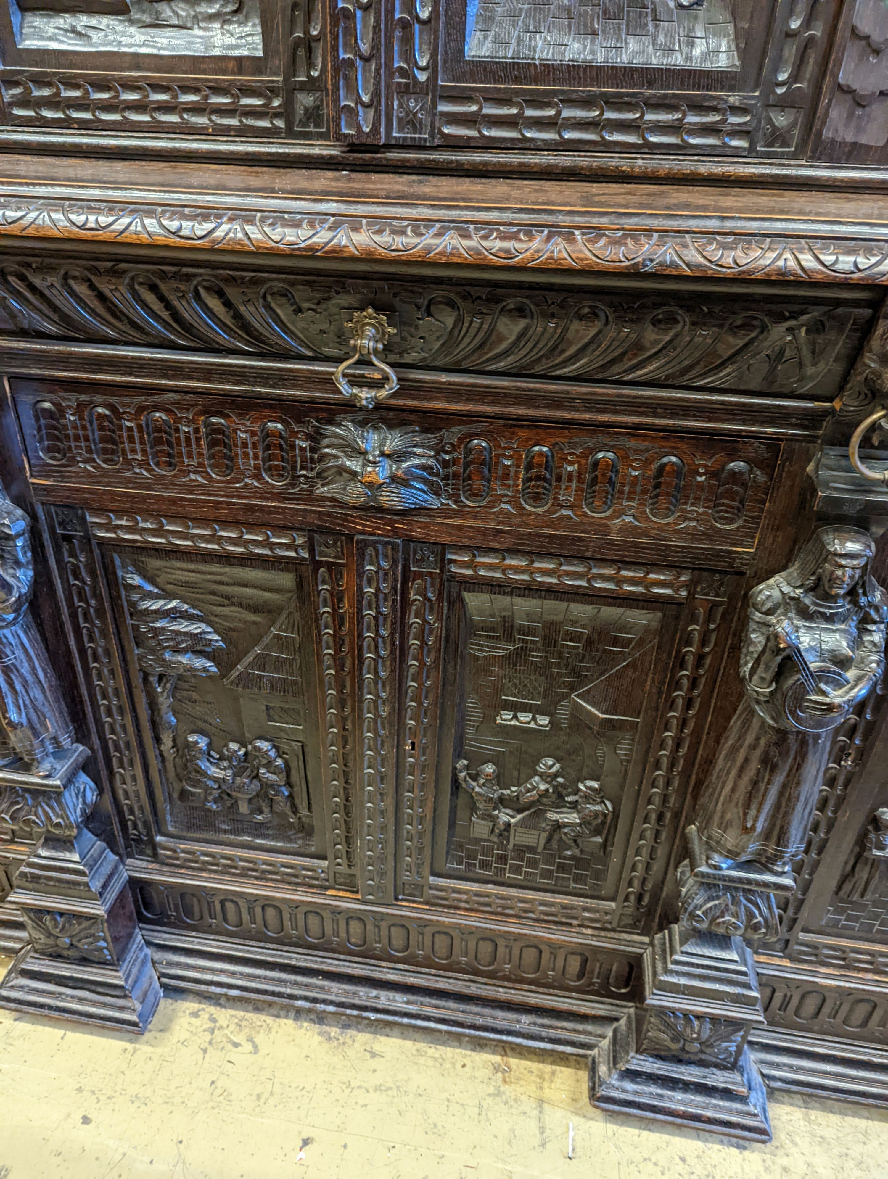 An early 20th century carved oak court cupboard in the Flemish style, length 200cm, depth 58cm, height 212cm